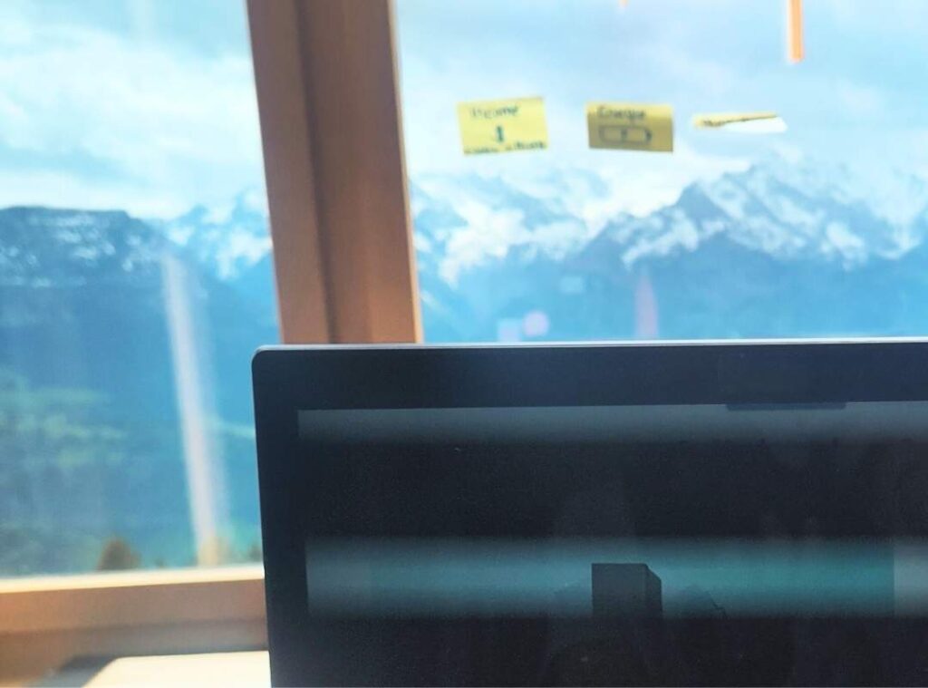Workspace with laptop and Alps in the background, representing Andreia Fernandes’ leadership, portfolio career coaching, and failure culture mindset.