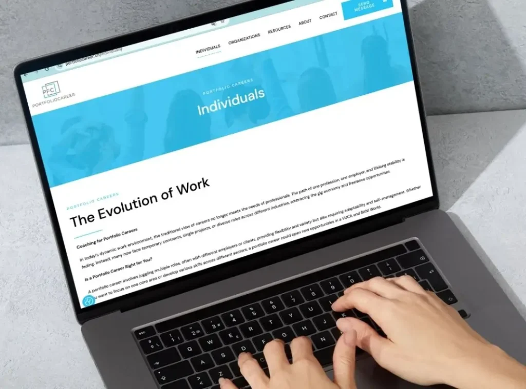 Hands typing on a laptop displaying “The Evolution of Work” article about portfolio careers – Andreia Fernandes coaching on leadership, failure culture, and building a portfolio career for the future of work.